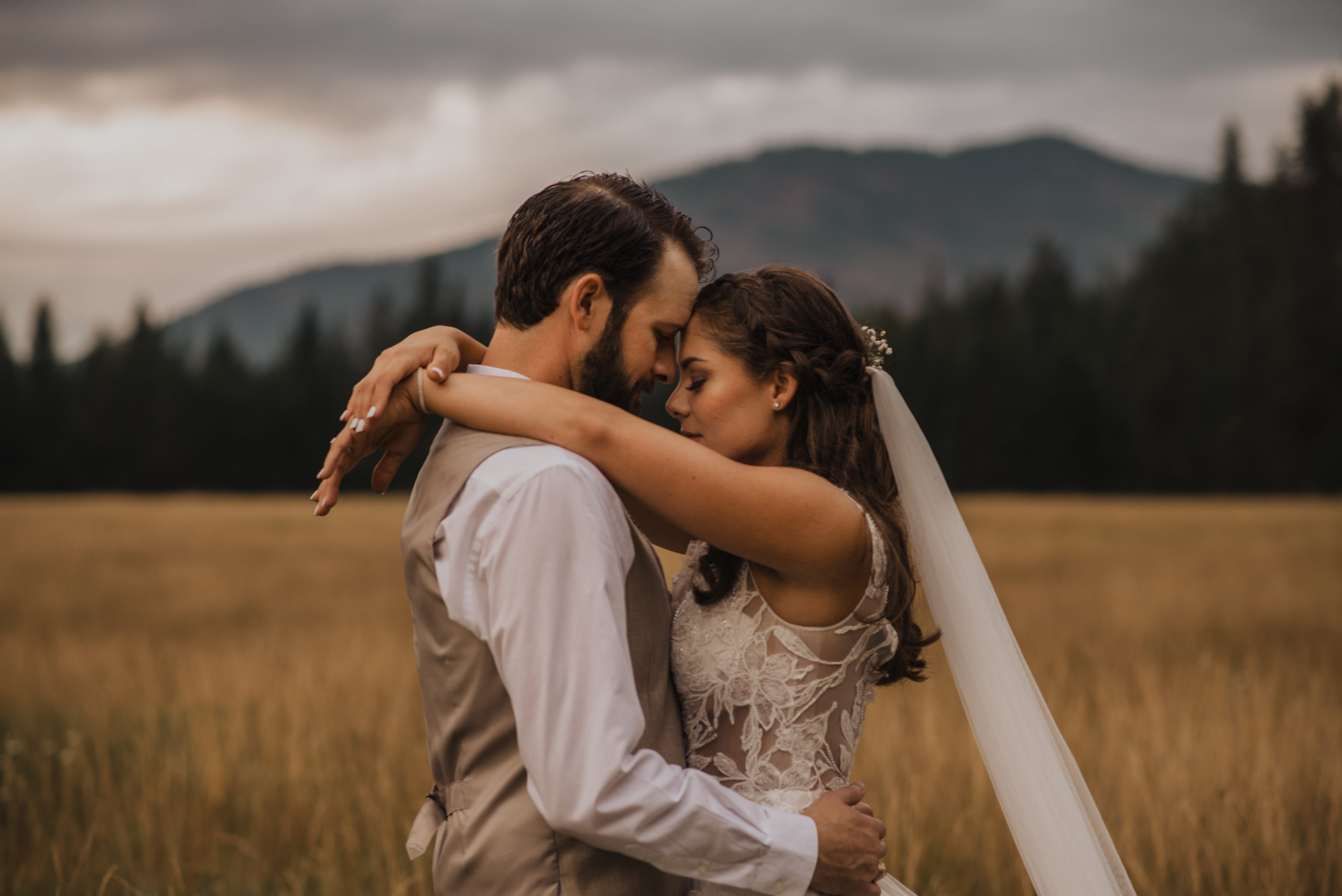 A newly married couple embracing at the base of the mountains in Troy, Montana.